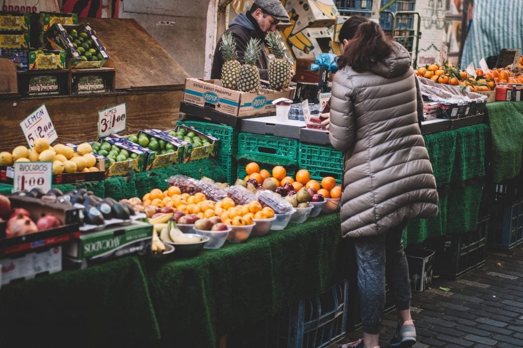 woman in front of fruit stands in market